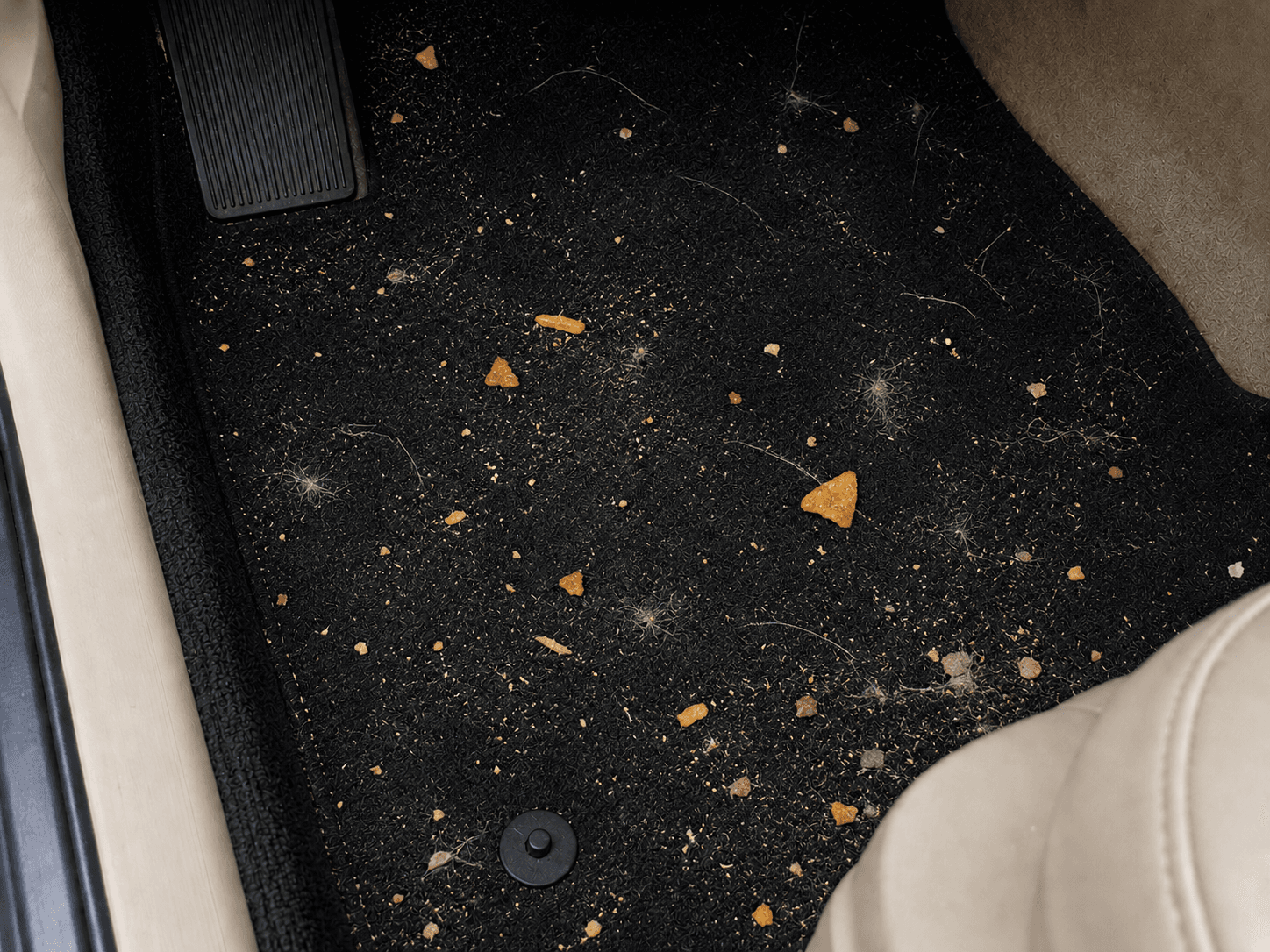 Messy car footwell before vacuuming